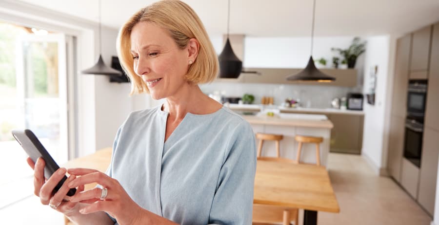 Resident holding a cell phone in a modern home
